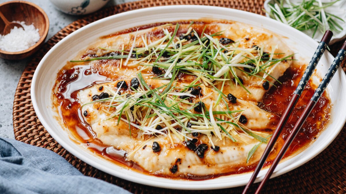 Steamed Fish with Black Bean Sauce serve on a plate with chop sticks
