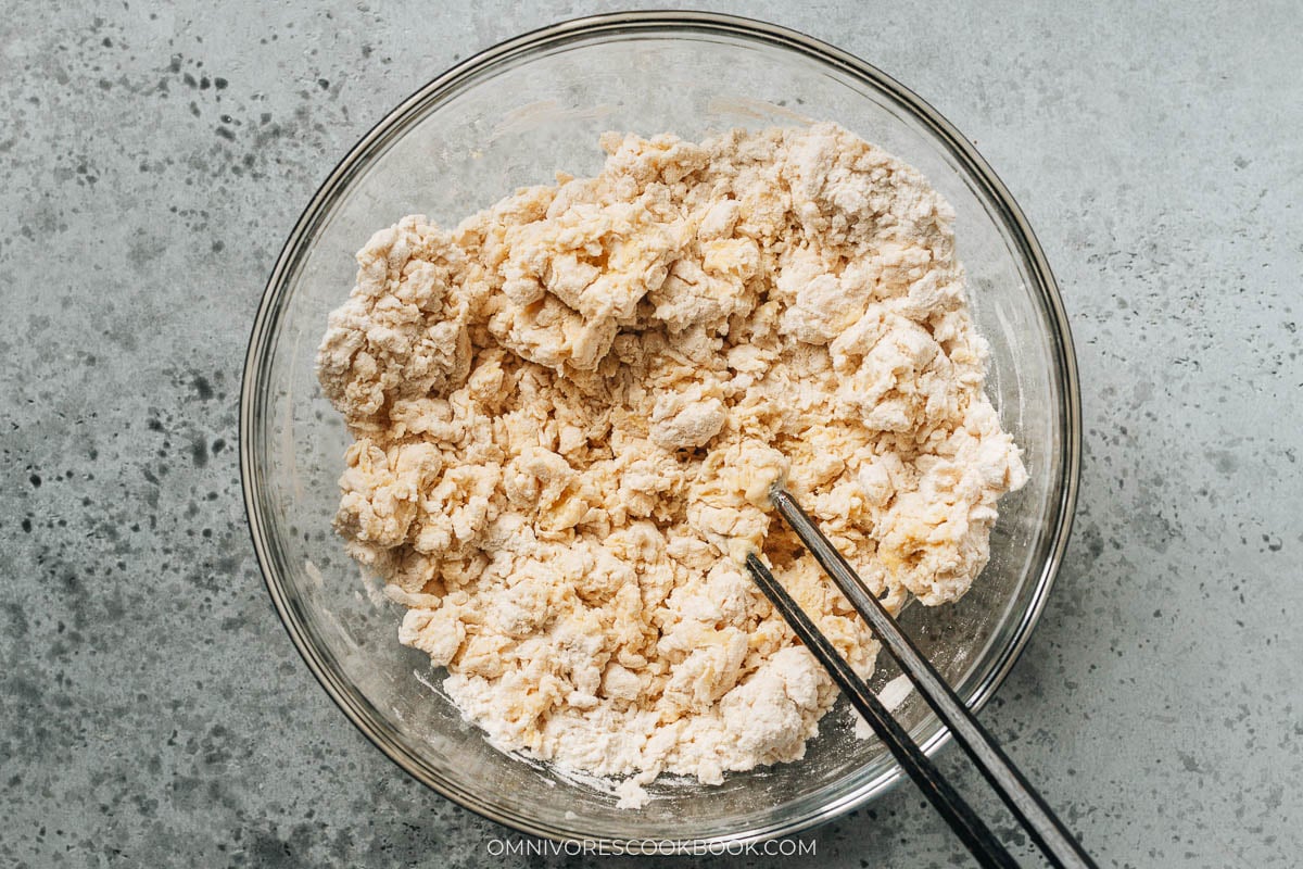 Stir the mixture until dough flakes form.