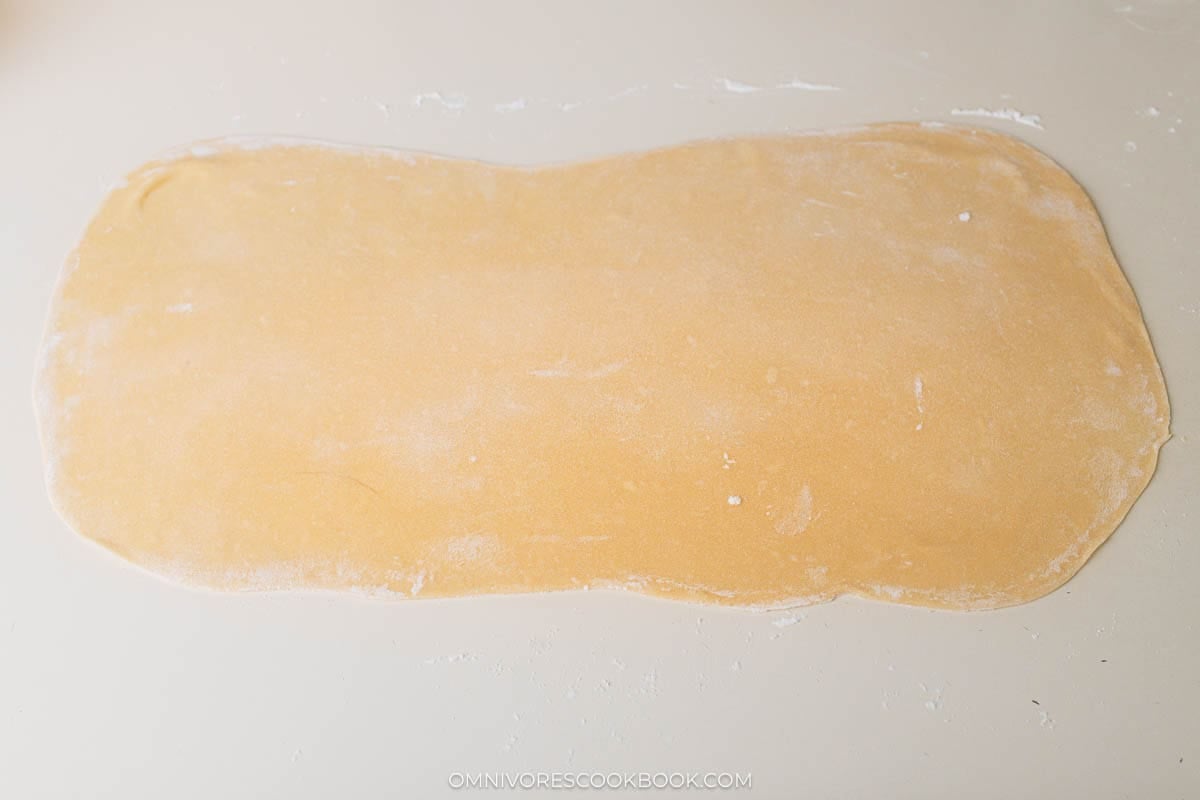 Roll the dough with a rolling pin to a large thin sheet.