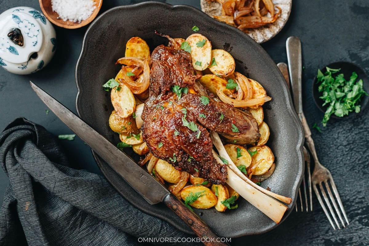 roast lamb shanks serve on a plate with veggies