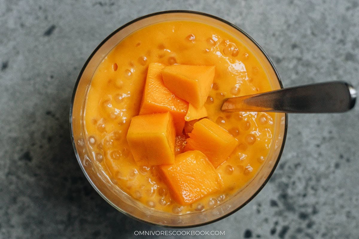 mango sago serve in a glass with fruit topping