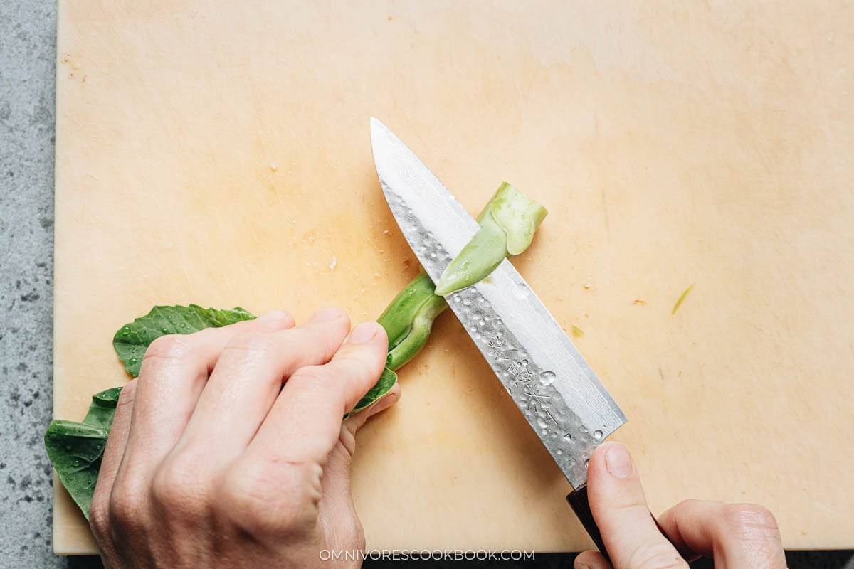 peeling the broccoli with a knife